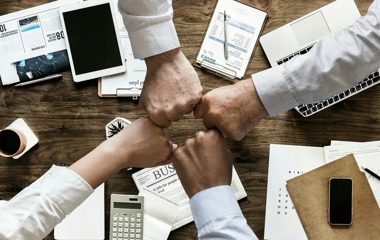 Poings réunis en signe de collaboration sur un bureau de travail libéral